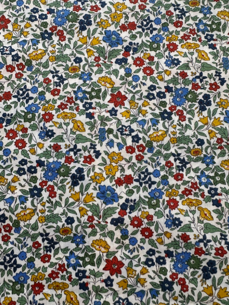 Patterned fabric with small flowers in red, blue, yellow, and green on a white background