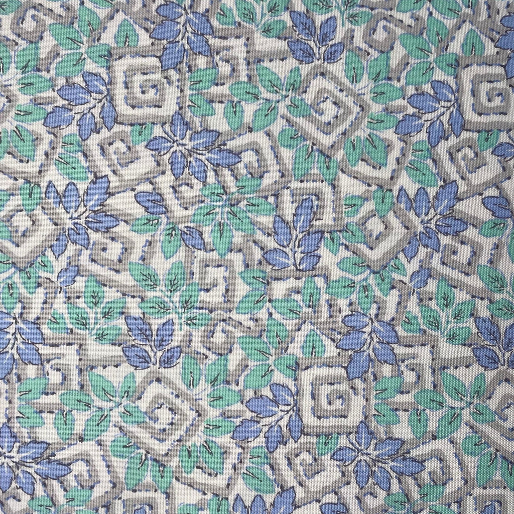 Patterned fabric with blue and green leaves on a gray background