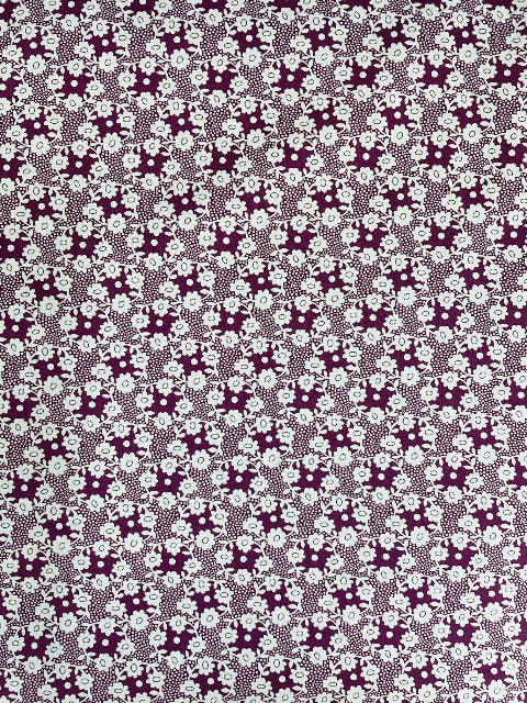 Patterned fabric with a repeating design of flowers and leaves.