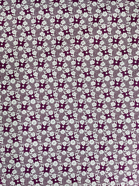 Patterned fabric with a repeating design of flowers and leaves.
