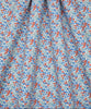 A close-up of a draped fabric with a dense floral print featuring red-orange berries and light blue leaves on a white background.