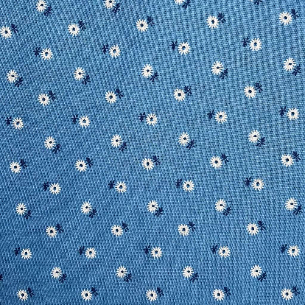 Pattern of white flowers with black centers on a blue background